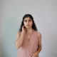 Mocha Ruffled Shift Dress with Pockets | Pocket Dress Woman wearing dusty mocha sleeveless shift dress with ruffled V-neckline and invisible side pockets, Pocket Dress India