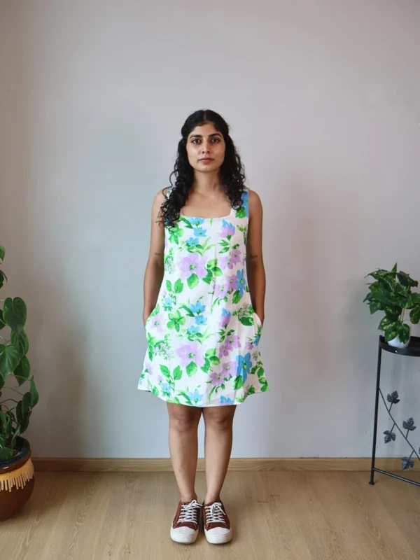 Pastel Floral Mini Dress with Pockets | Pocket Dress Woman wearing white A-line mini dress with lavender, sky blue, and green floral print and invisible side pockets, Pocket Dress India