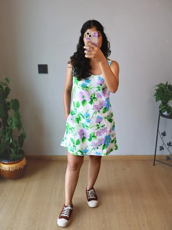 Pastel Floral Mini Dress with Pockets | Pocket Dress Woman wearing white A-line mini dress with lavender, sky blue, and green floral print and invisible side pockets, Pocket Dress India