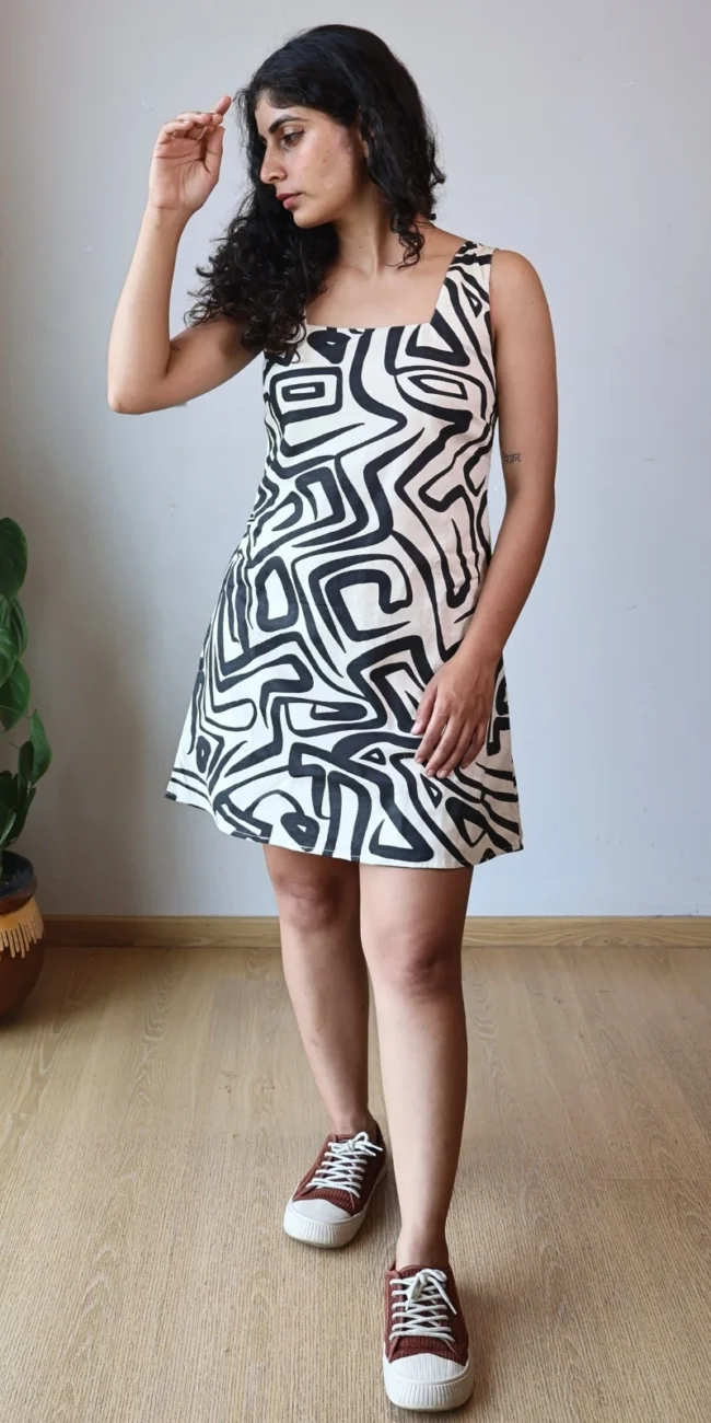 Woman wearing black and off-white geometric abstract print A-line mini dress with invisible side pockets, Pocket Dress India